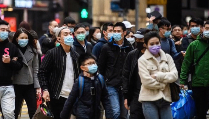 Crowd of people outdoors wearing masks