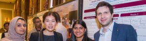 A group of four people smiling at the research excellence and discovery day