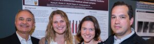 A group of four people in front of posters at the research excellence and discovery day