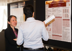 Two people talking in front of a research poster